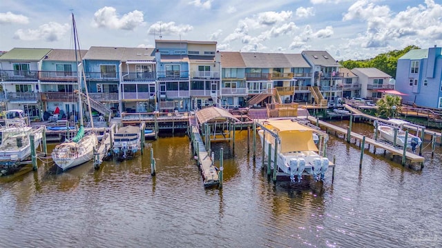 view of dock with a balcony and a water view