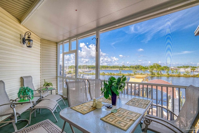 sunroom featuring a water view