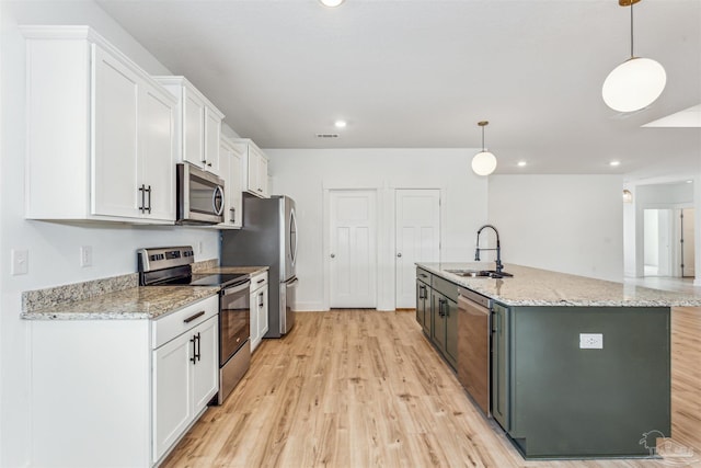 kitchen with stainless steel appliances, hanging light fixtures, sink, and white cabinets