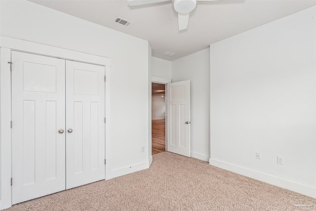 unfurnished bedroom with ceiling fan, a closet, and carpet