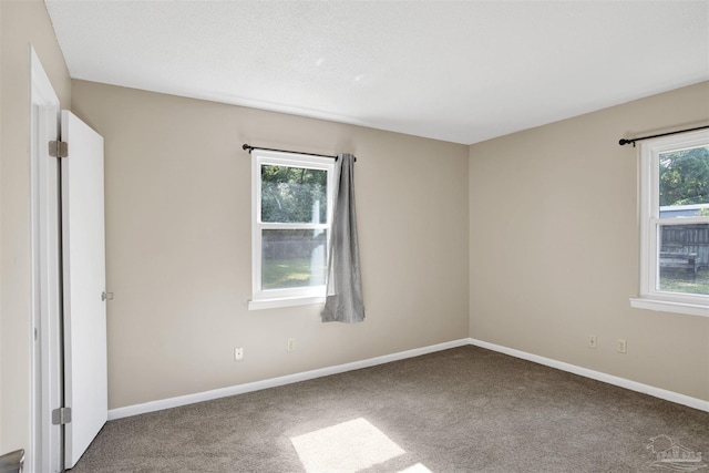 unfurnished room with carpet floors and baseboards