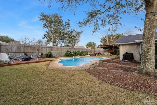 view of swimming pool featuring a wooden deck, a yard, and a grill