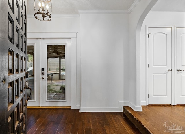 entryway with crown molding, dark hardwood / wood-style floors, french doors, and a textured ceiling