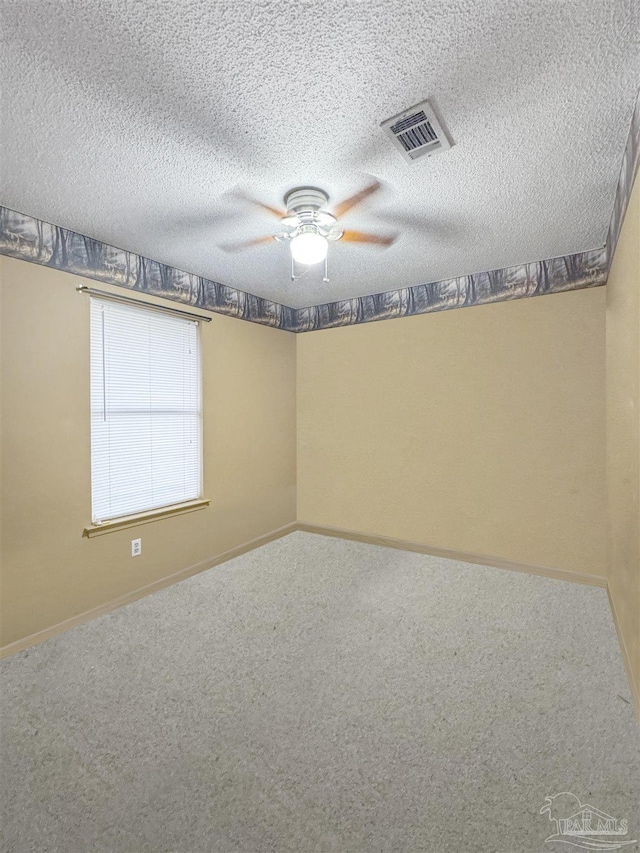 carpeted empty room with ceiling fan and a textured ceiling