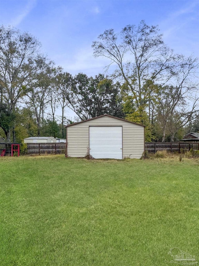 view of yard featuring a garage and an outbuilding