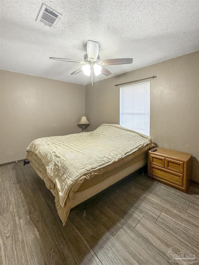 bedroom featuring a textured ceiling, ceiling fan, and hardwood / wood-style floors