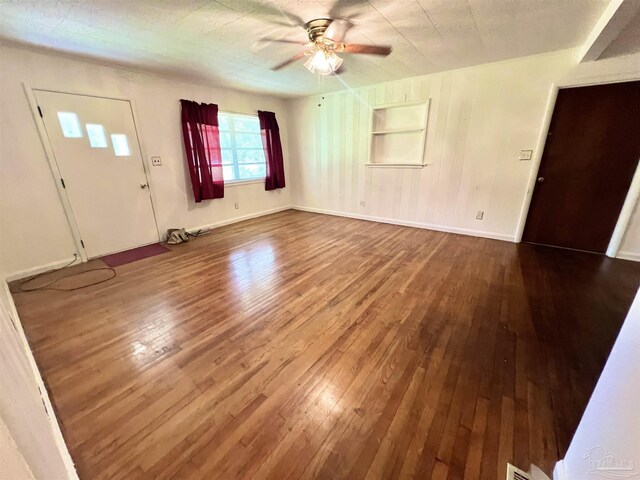 interior space with built in features, ceiling fan, and wood-type flooring