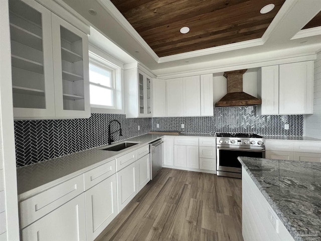 kitchen featuring wall chimney range hood, wood ceiling, stainless steel appliances, a raised ceiling, and a sink