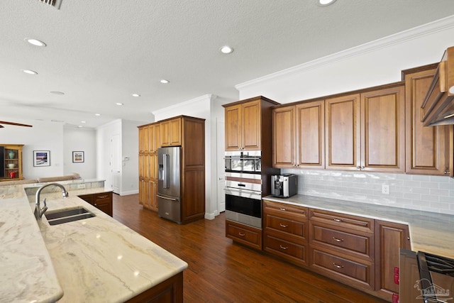 kitchen featuring tasteful backsplash, a sink, high end refrigerator, and light stone countertops