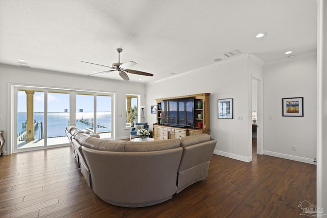 living room with dark wood-style flooring, crown molding, and baseboards