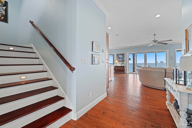 stairs featuring hardwood / wood-style flooring and ceiling fan