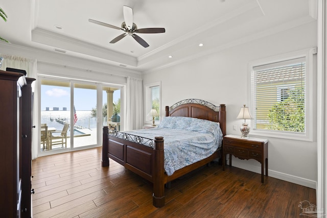 bedroom with access to exterior, a raised ceiling, and dark wood-style flooring