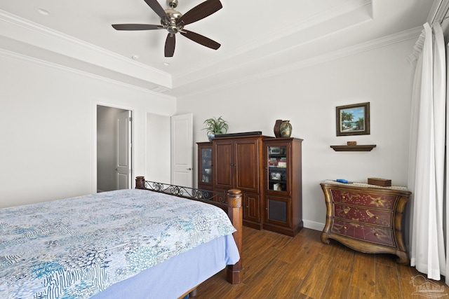 bedroom featuring crown molding, a raised ceiling, dark wood finished floors, and a ceiling fan