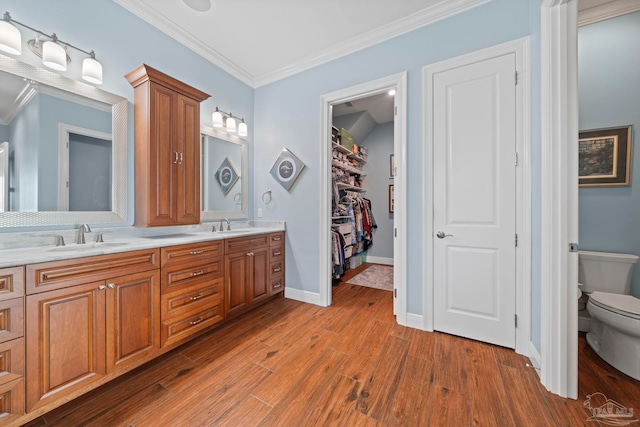 bathroom featuring hardwood / wood-style floors, vanity, toilet, and ornamental molding