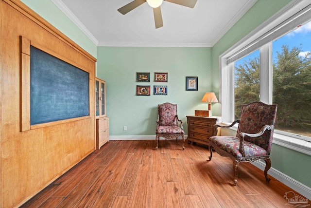 sitting room with crown molding, ceiling fan, and wood-type flooring