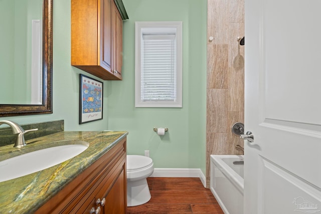 full bathroom with vanity, hardwood / wood-style flooring, toilet, and tiled shower / bath combo