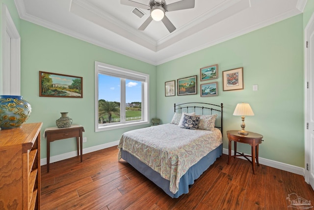 bedroom with ornamental molding, a raised ceiling, ceiling fan, and dark wood-type flooring