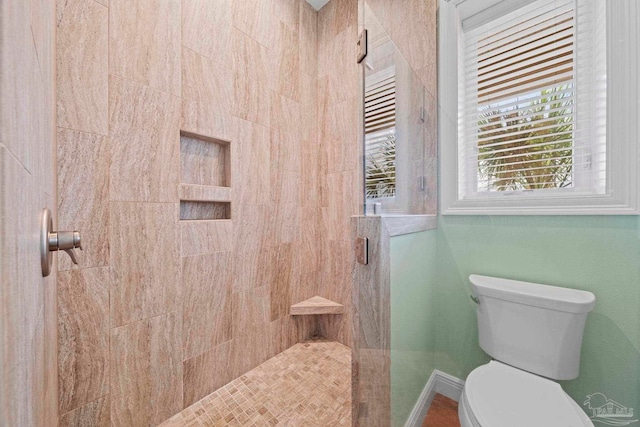 bathroom featuring toilet and tiled shower