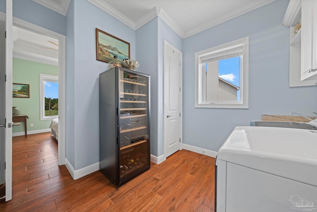 washroom with cabinets, hardwood / wood-style flooring, ornamental molding, and sink