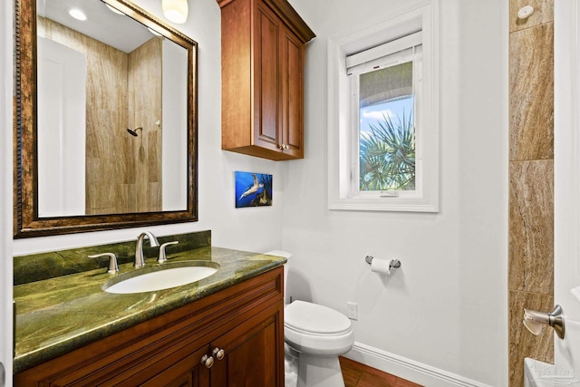 bathroom featuring vanity, toilet, and baseboards