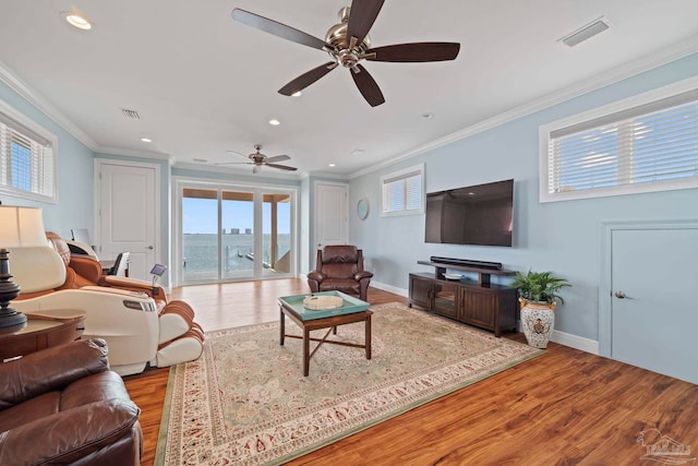 living room featuring light hardwood / wood-style floors, ceiling fan, and crown molding