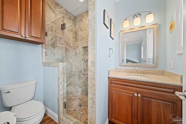 bathroom with vanity, hardwood / wood-style flooring, toilet, and a shower with door