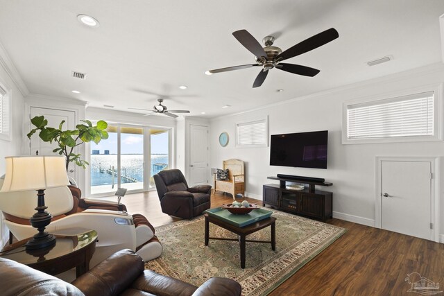 living area featuring dark wood finished floors, visible vents, and crown molding