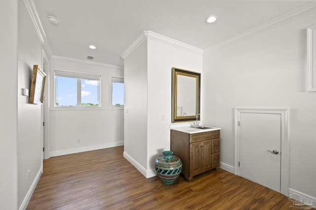 interior space featuring recessed lighting, wood finished floors, vanity, baseboards, and ornamental molding