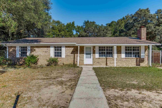 ranch-style home with covered porch and a front yard