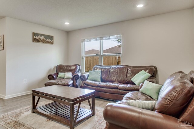 living room with recessed lighting, light wood-style flooring, and baseboards