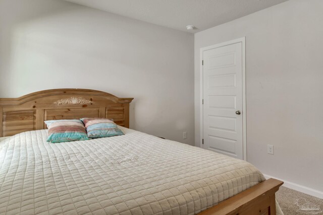 bedroom featuring carpet and baseboards