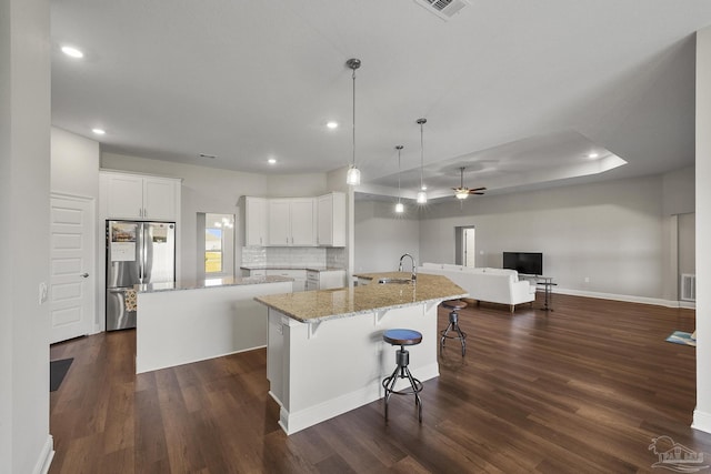 kitchen with dark wood-style flooring, a sink, a spacious island, and freestanding refrigerator