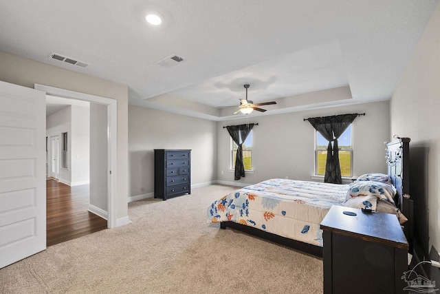 bedroom featuring baseboards, visible vents, and a raised ceiling