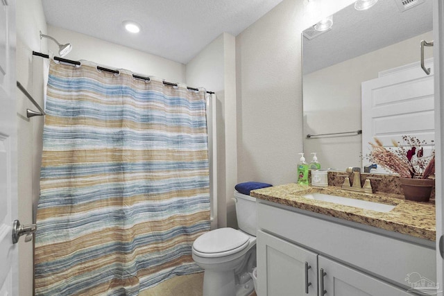 bathroom with curtained shower, toilet, vanity, and a textured ceiling