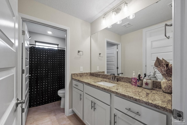 full bath with toilet, vanity, a textured ceiling, and visible vents