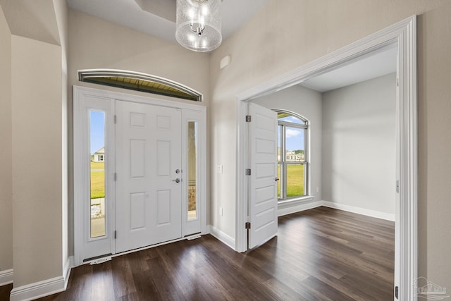foyer with baseboards and dark wood-style flooring