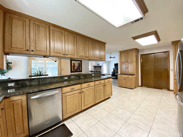 kitchen featuring dishwasher, light tile patterned floors, kitchen peninsula, and dark stone countertops