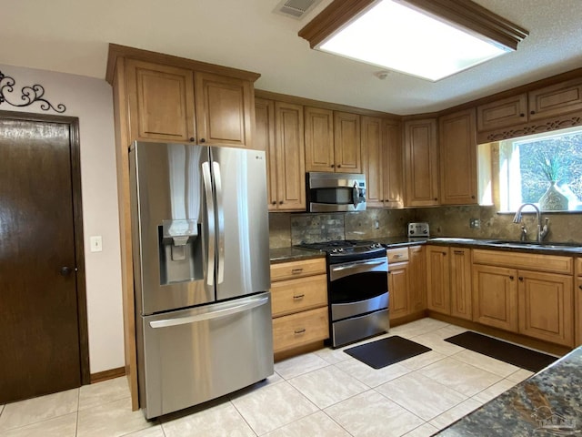 kitchen featuring stainless steel appliances, light tile patterned flooring, sink, and decorative backsplash