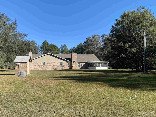 view of home's exterior featuring a sunroom and a yard