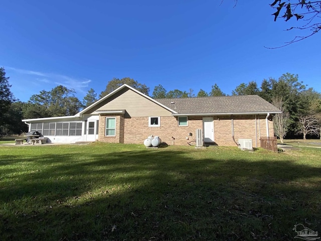 back of house with a yard and a sunroom