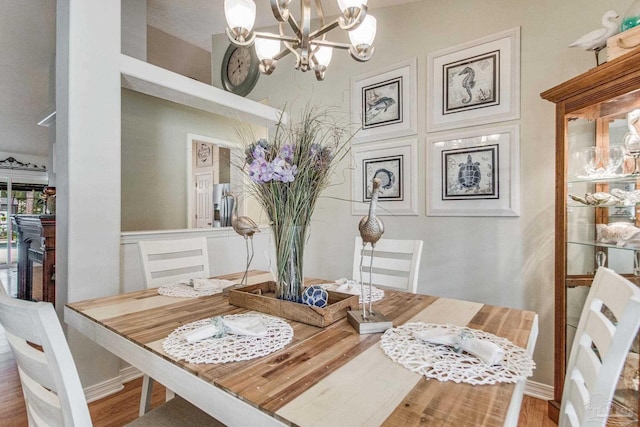 dining area featuring hardwood / wood-style floors and an inviting chandelier