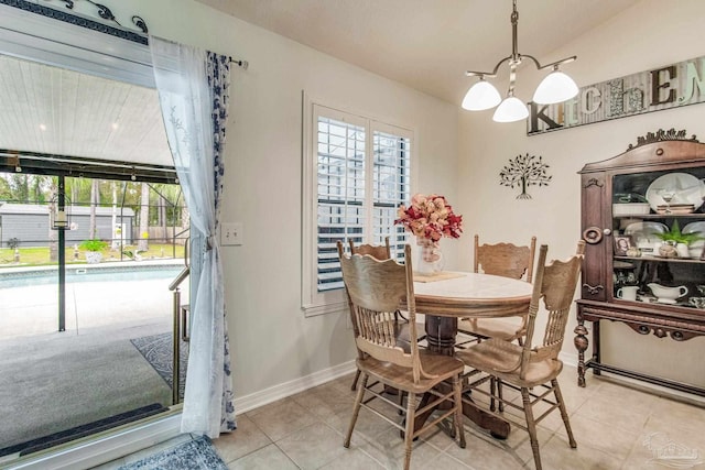 tiled dining area featuring a chandelier