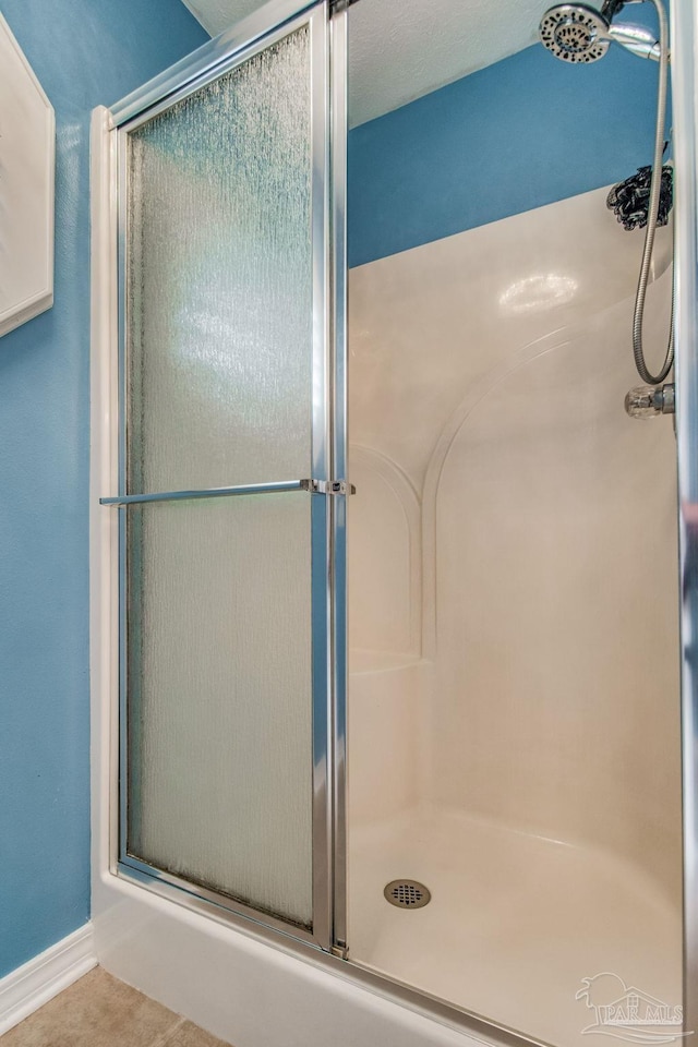 bathroom with tile patterned flooring and an enclosed shower