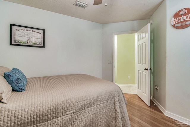 bedroom featuring ceiling fan, a textured ceiling, and light hardwood / wood-style flooring