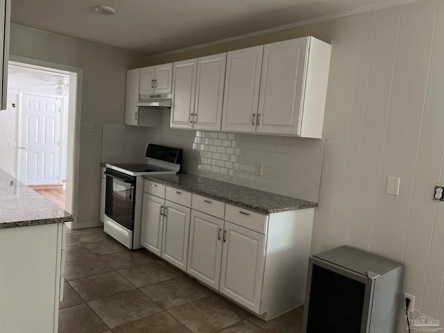 kitchen featuring decorative backsplash, white range with electric cooktop, dark tile patterned floors, and white cabinets