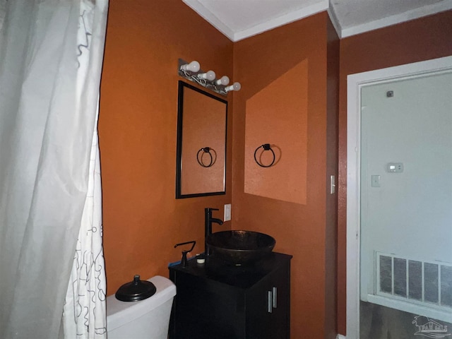 bathroom with toilet, vanity, visible vents, and crown molding