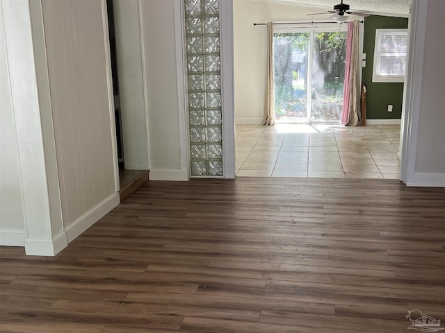 unfurnished dining area with baseboards, a ceiling fan, and wood finished floors