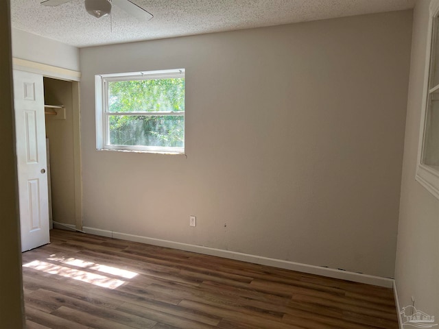 unfurnished bedroom featuring a closet, ceiling fan, dark wood-type flooring, and a textured ceiling