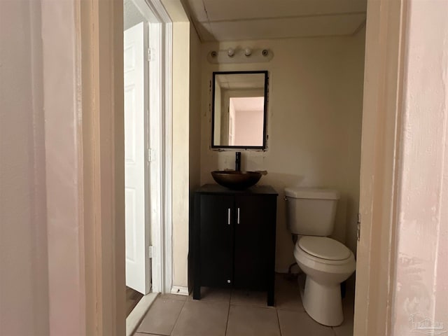 half bath with toilet, tile patterned flooring, and vanity