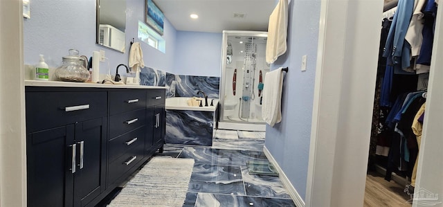 bathroom featuring vanity and independent shower and bath